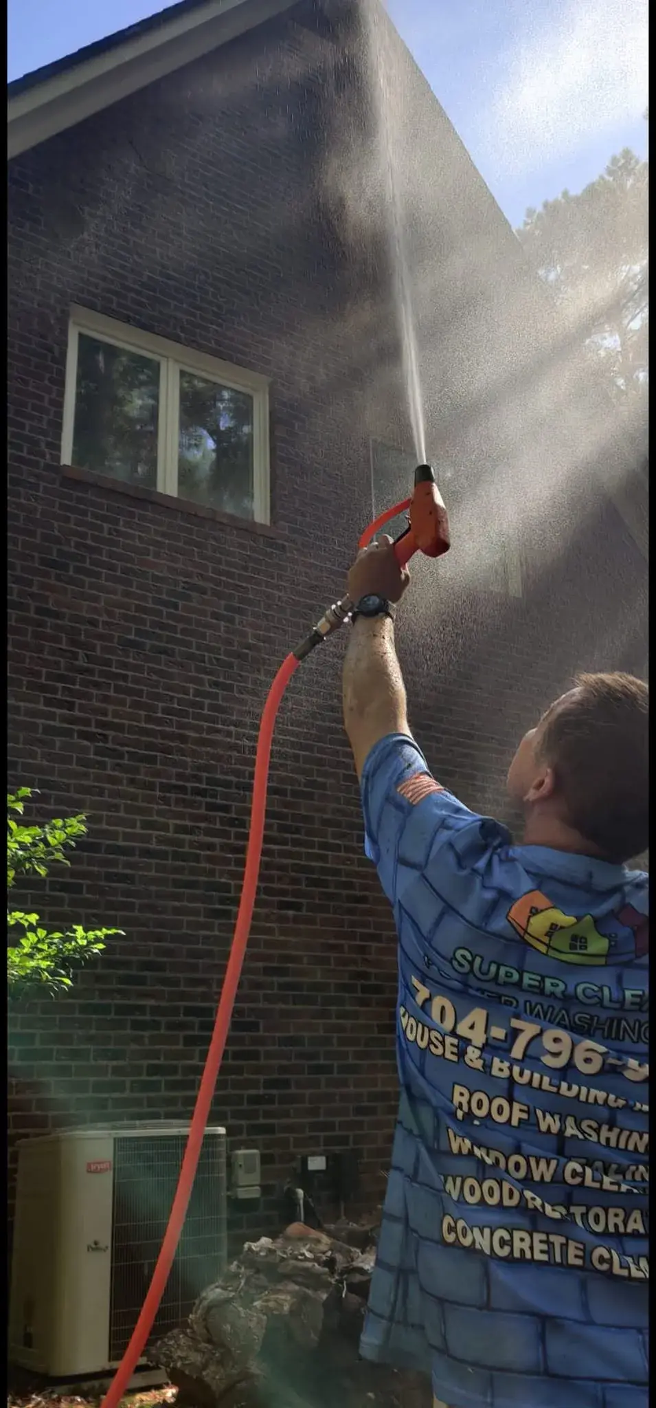 Super Clean Power Washing technician soft washing the exterior of a brick home